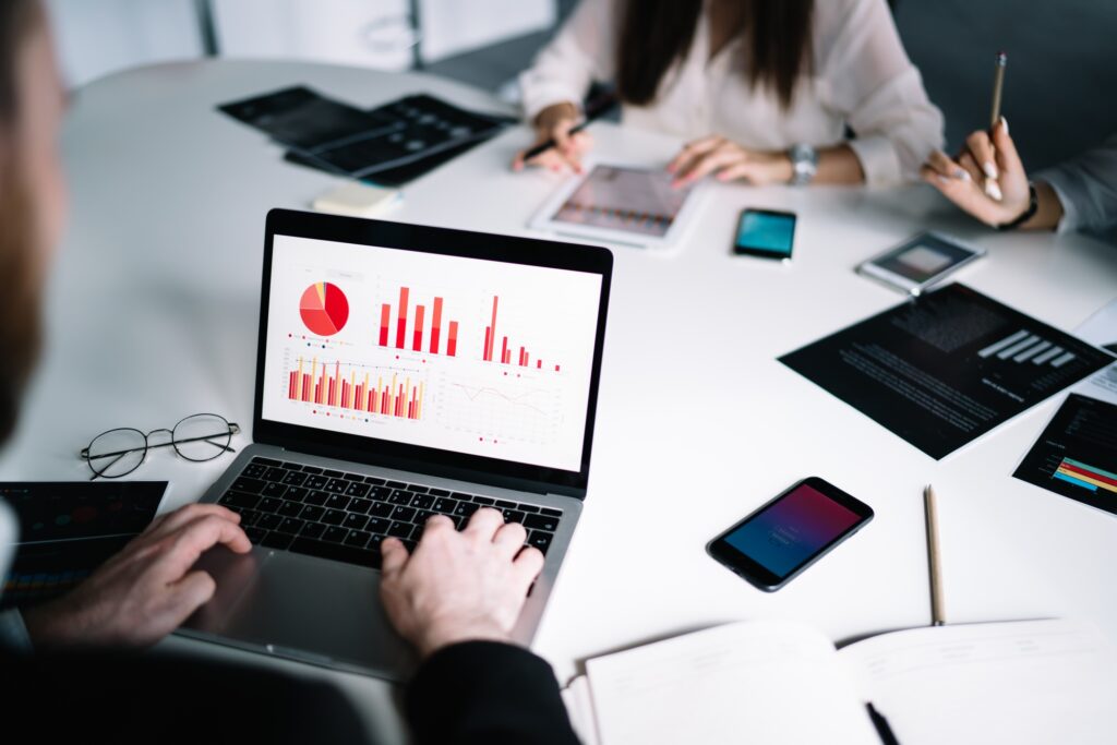 Anonymous employee browsing laptop with charts on screen