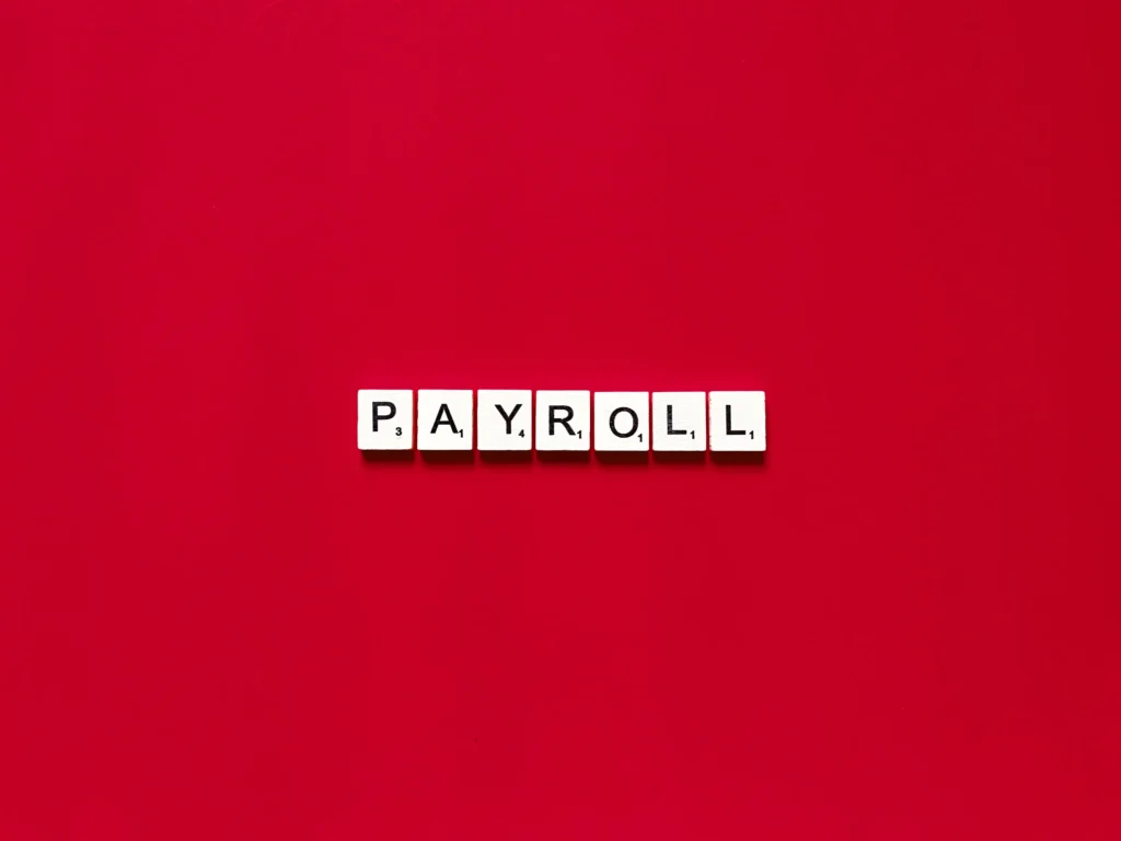 payroll spelled out with letter tiles on red